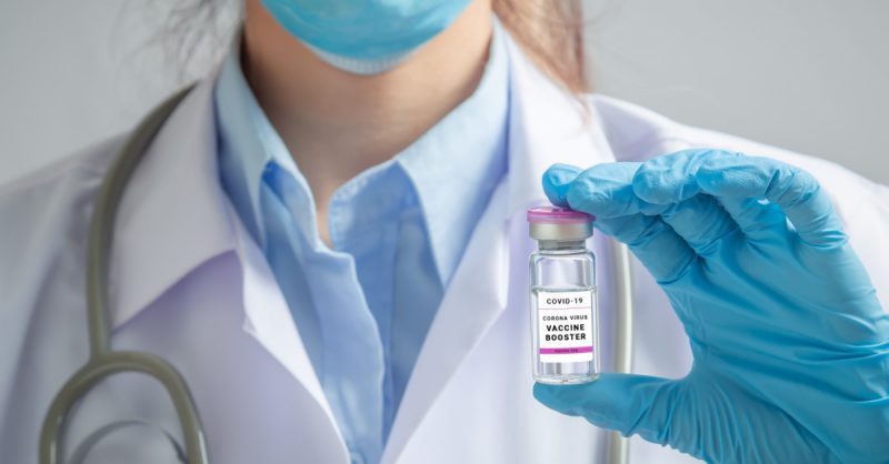 Doctor holding COVID-19 Booster Vaccine