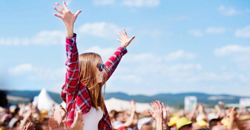 Woman with hands in the air at music festival Fun Activities