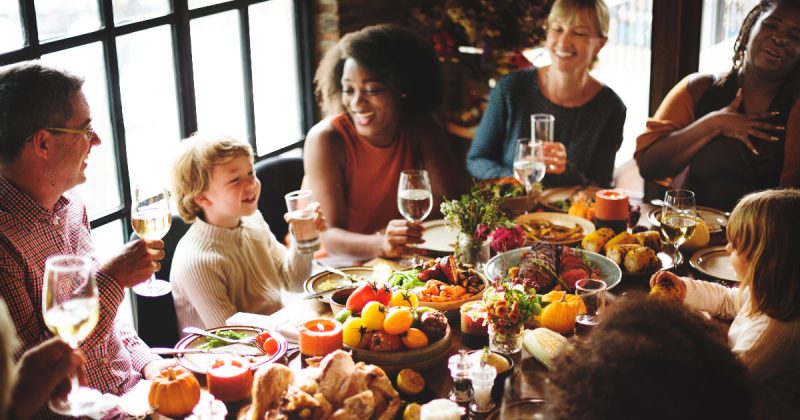 Family at Thanksgiving Dinner with table full of food dishes
