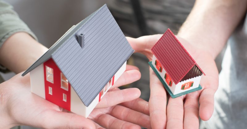 People holding models of homes in hands