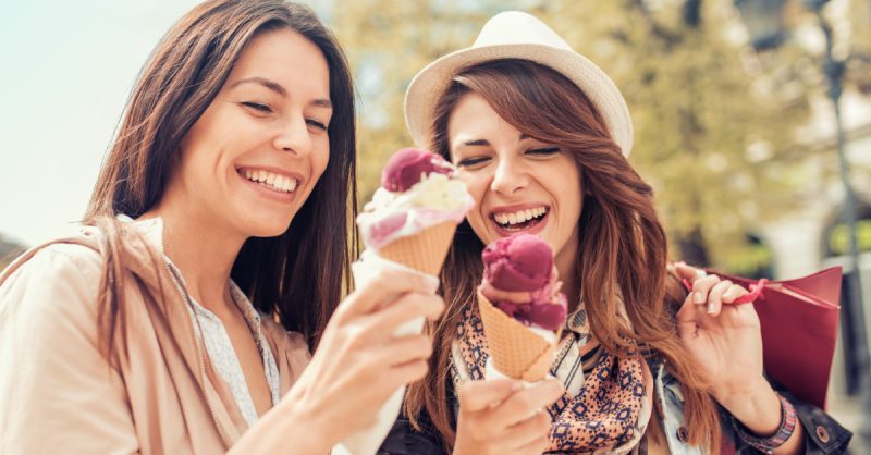 Friends,,Two,Women,with,Shopping,Bags,In,The,City.sale,consumerism,And,People 2 Women enjoying ice cream in waffle cones
